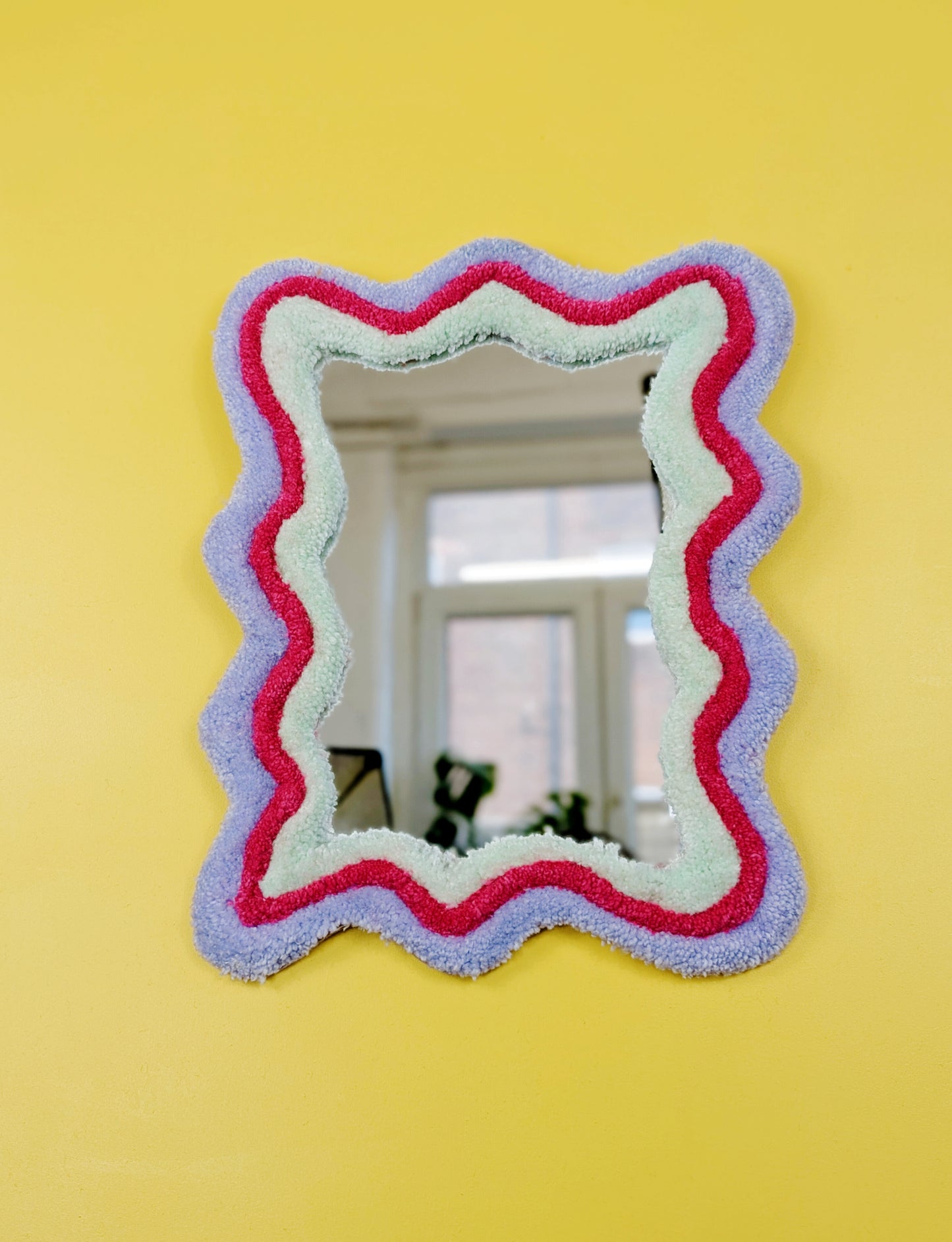 Handmade wavy tufted mirror with colourful textured frame in pastel purple, mint green, and pink, modern aesthetic wall décor for home interiors.