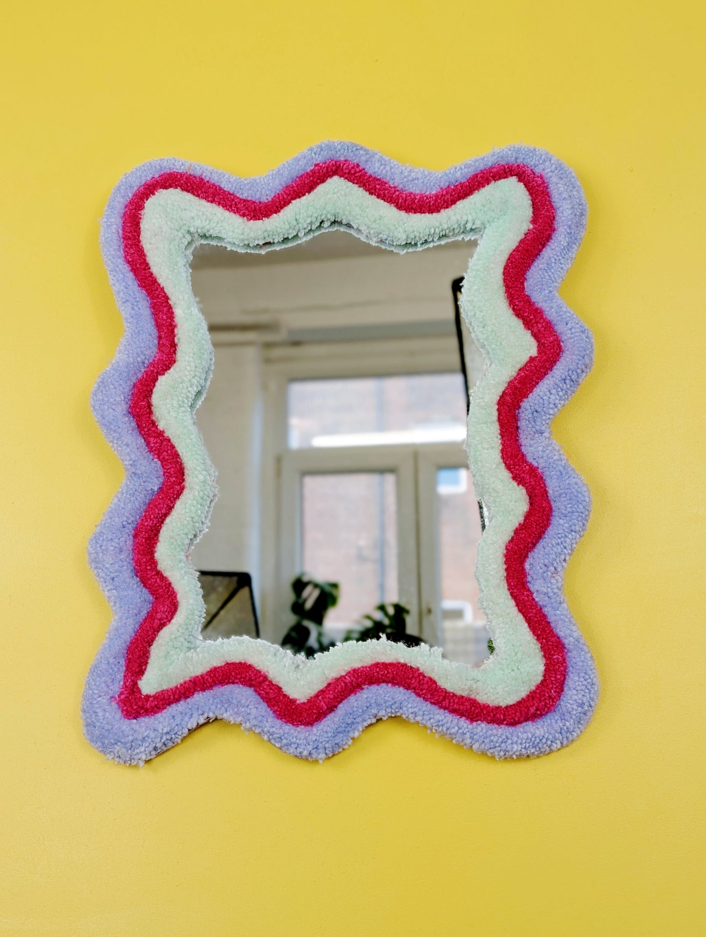 Handmade wavy tufted mirror with colourful textured frame in pastel purple, mint green, and pink, modern aesthetic wall décor for home interiors.