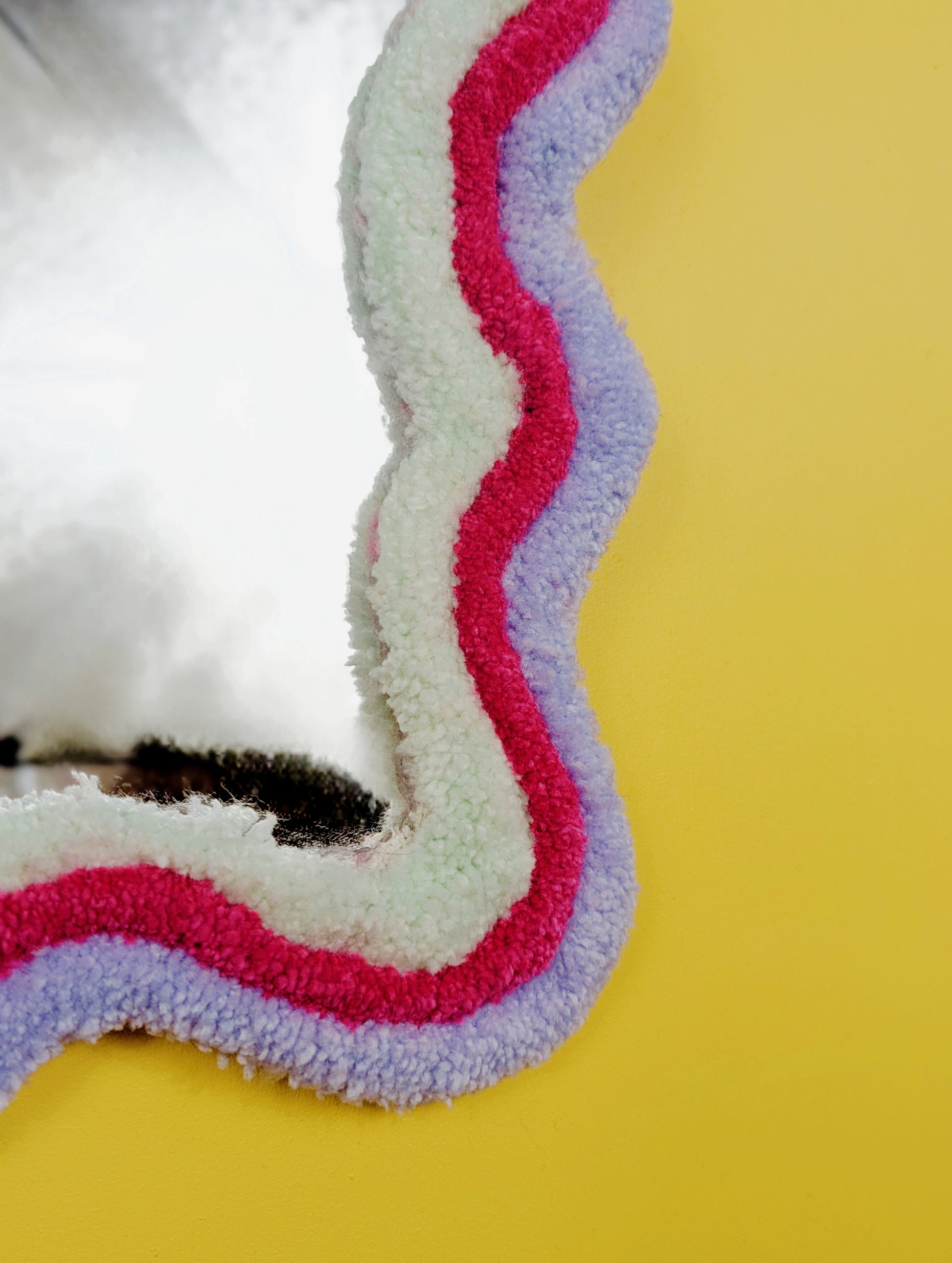 Handmade wavy tufted mirror with colourful textured frame in pastel purple, mint green, and pink, modern aesthetic wall décor for home interiors.