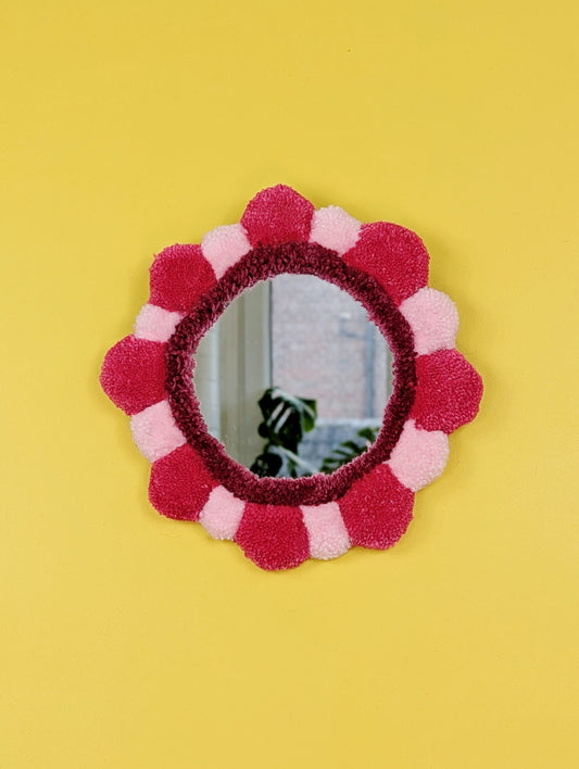 Handmade tufted petal mirror with pink textured yarn petals surrounding a round mirror